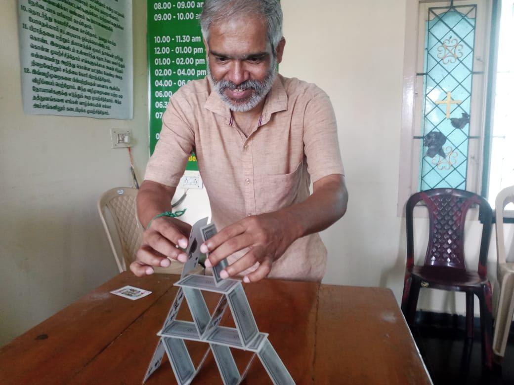 A resident building a house of cards during an occupational therapy session at the centre